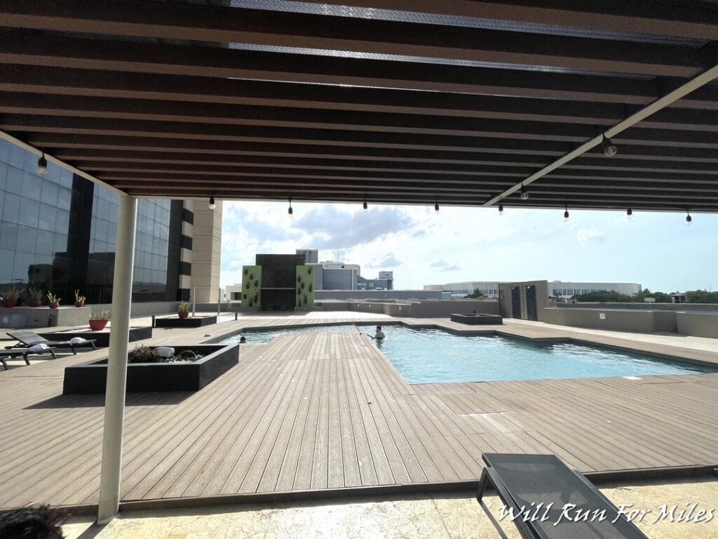 a pool with a deck and a building in the background