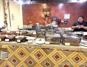 a man standing behind a counter with food on it