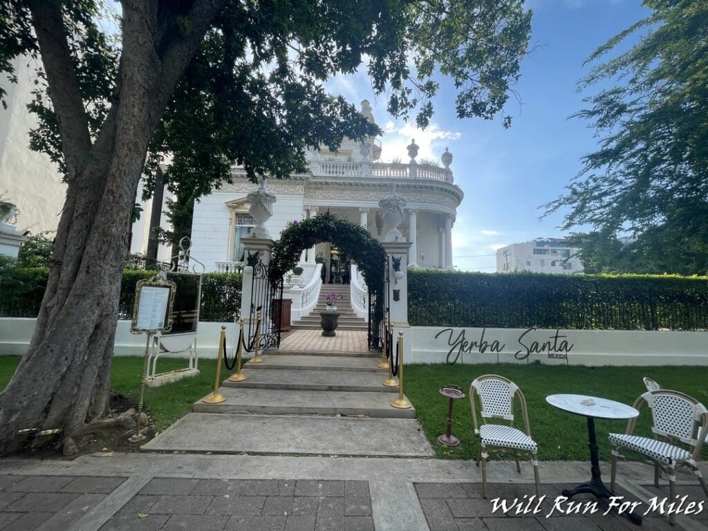 a white building with a white archway and a white fence
