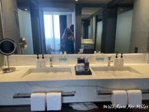 a woman taking a picture of a bathroom sink