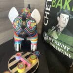 a colorful dog statue next to a book