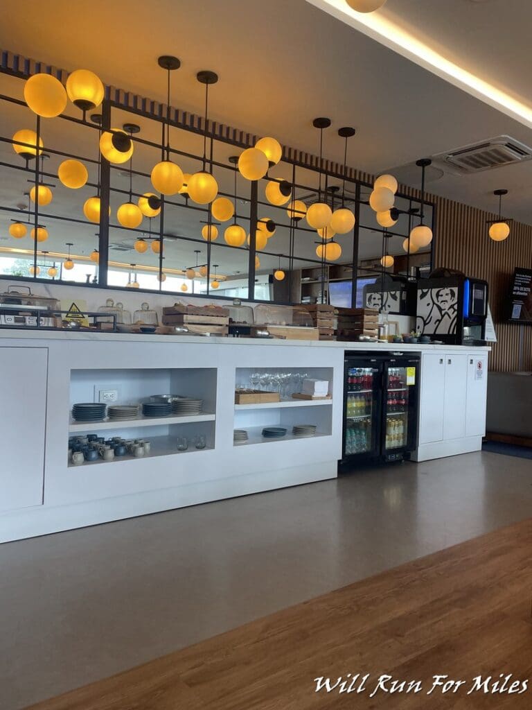 a room with a counter and a mirror with lights from it