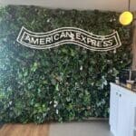 a wall of plants with a sign on it