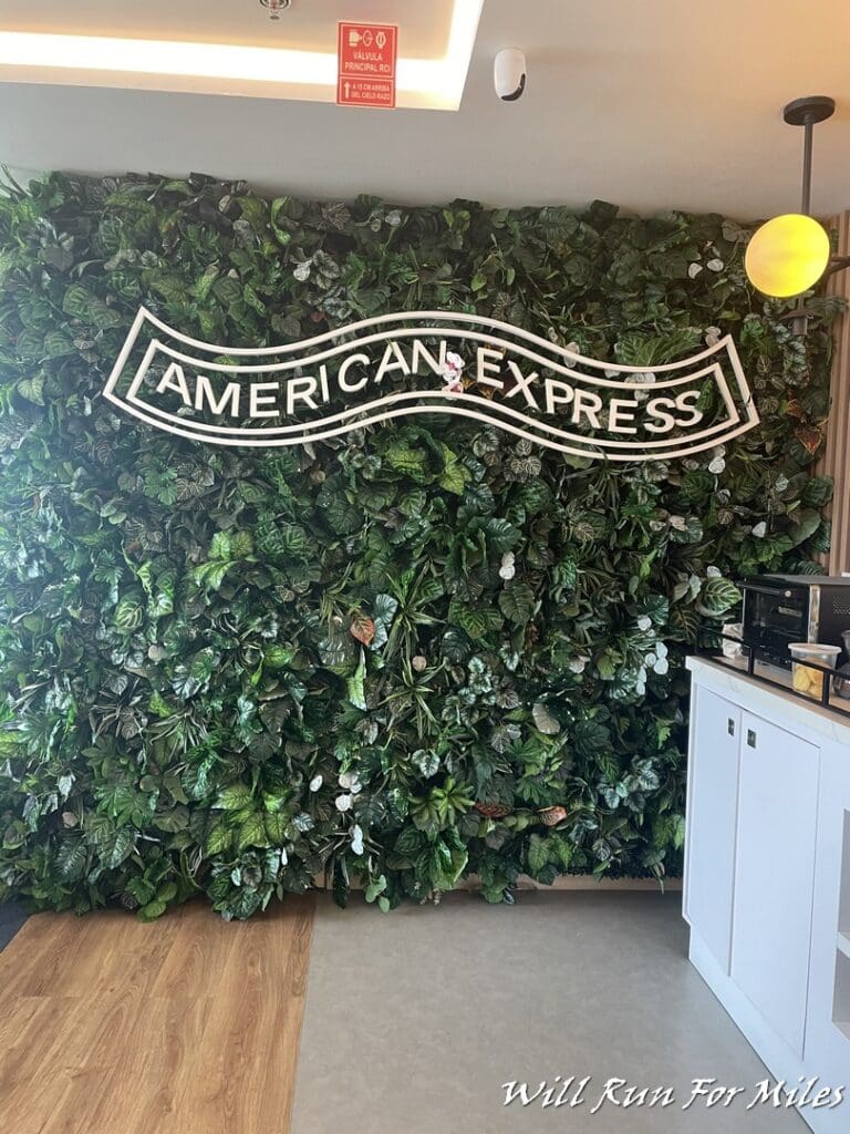 a wall of plants with a sign on it