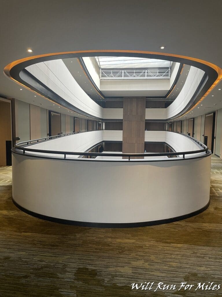 a room with a round white wall and a black railing