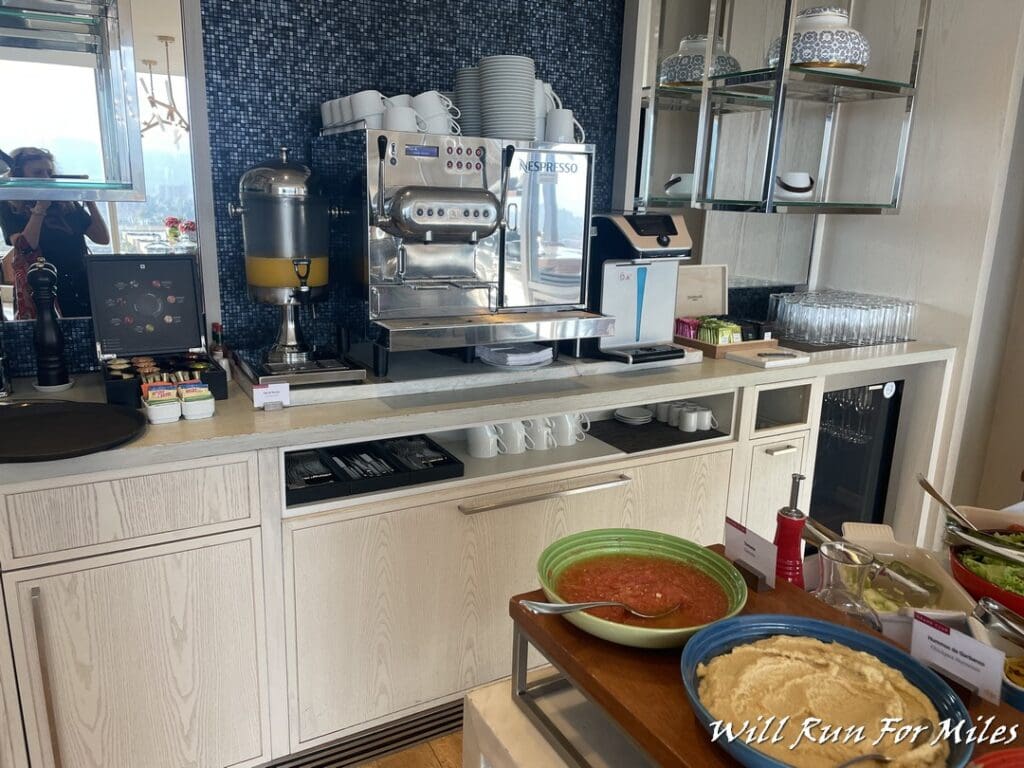 a coffee machine and bowls of soup on a counter