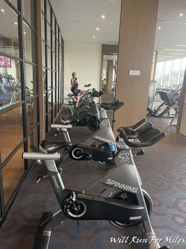 a woman sitting on exercise bikes in a gym