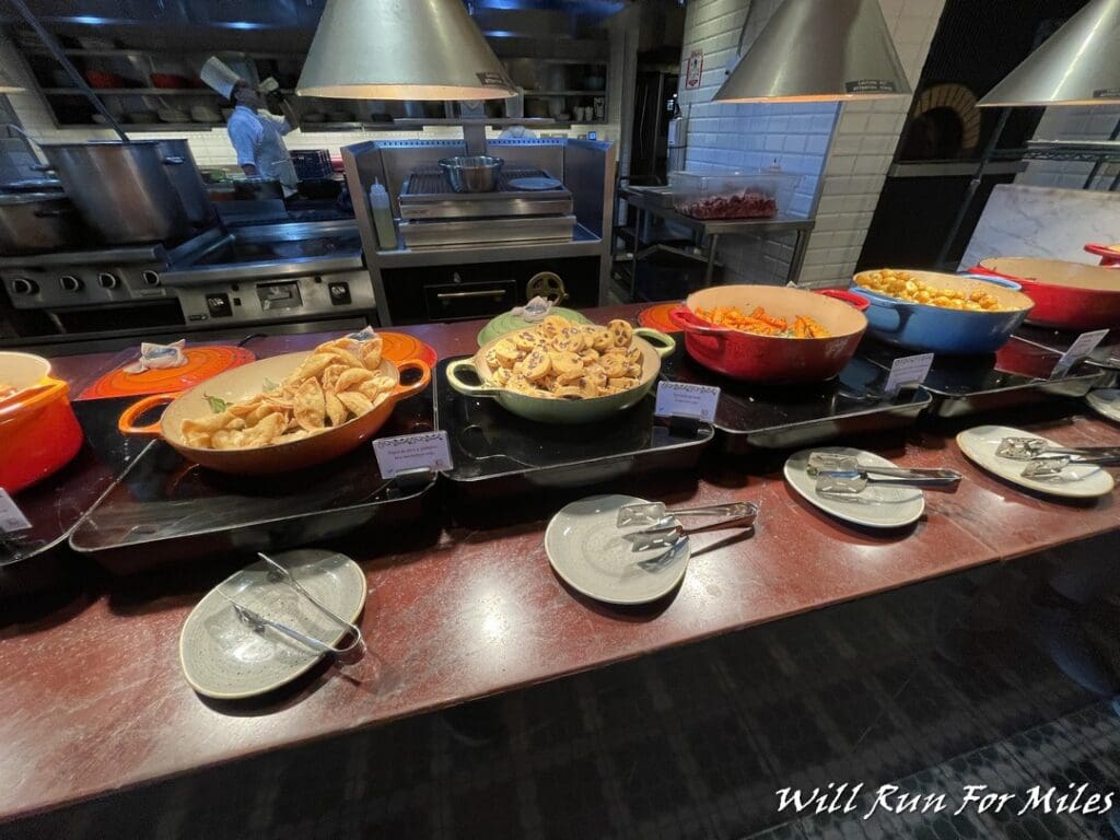 a row of bowls of food on a counter
