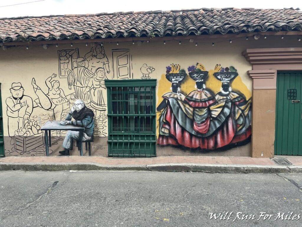 a wall with a painting of people sitting at a table