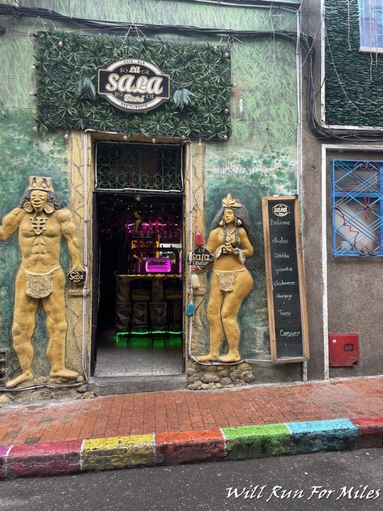 a building with a sign and statues on the wall