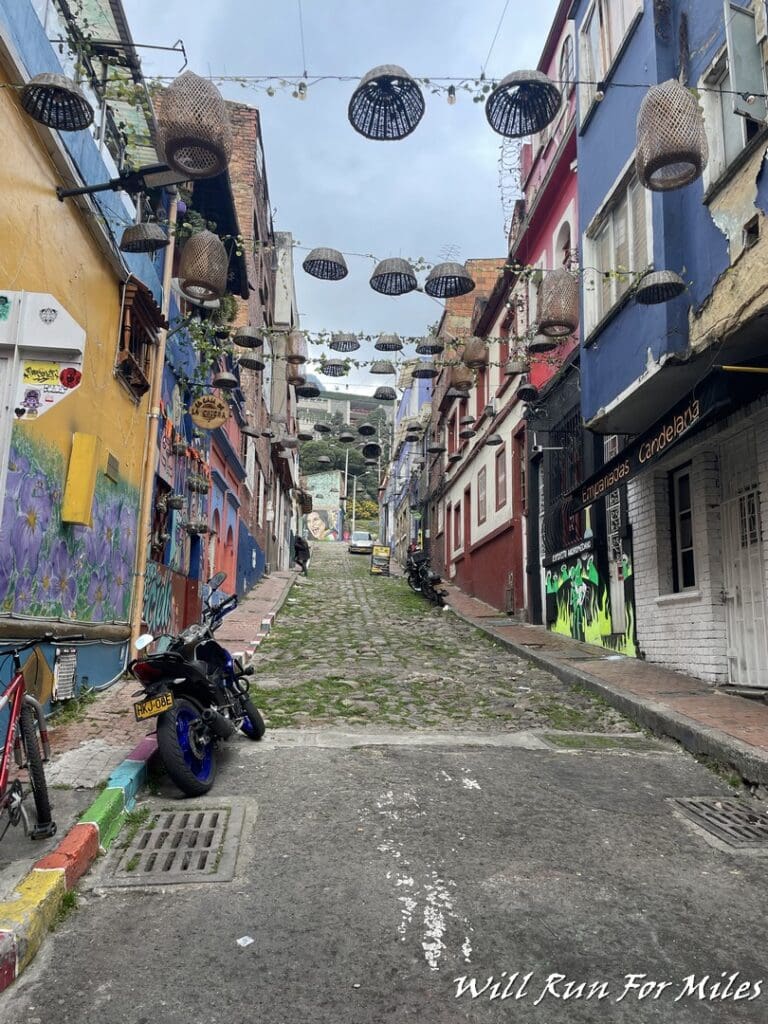 a street with buildings and baskets from the ceiling