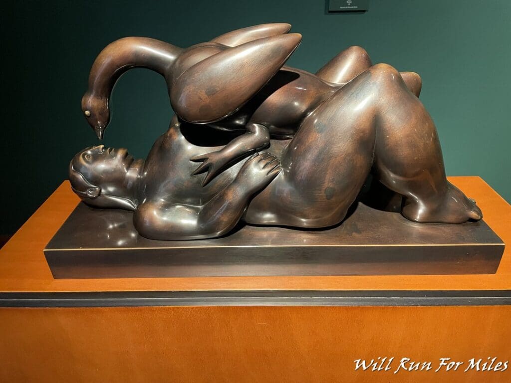 a statue of a man lying down with a bird on it