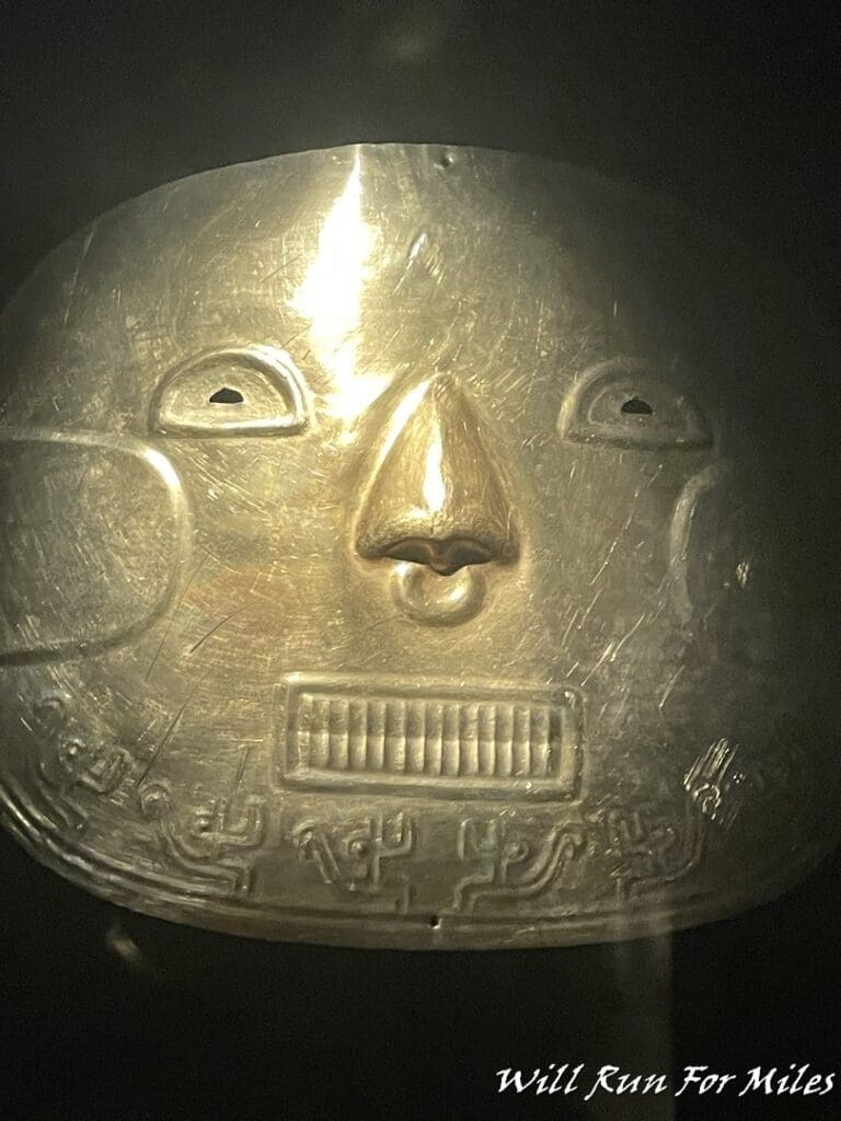 a gold plate with a face and a nose